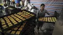 Seorang tukang roti memasukkan penganan manis ke dalam oven di toko roti tradisional menjelang bulan puasa Ramadan mendatang, di Kabul, Afghanistan, pada 7 April 2021. Sebentar lagi, umat Muslim di seluruh dunia akan menyambut bulan Ramadan.  (AP Photo / Rahmat Gul)
