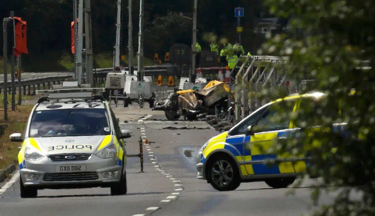 Tim penyelamat dan petugas investigasi berada di lokasi jatuhnya jet Hawker Hunter di Jalan Raya A27, Shoreham, Inggris, Minggu (23/8/2015). Pesawat yang tengah mengikuti Shoreham Airshow tersebut menewaskan sedikitnya tujuh orang.(REUTERS/Luke MacGregor)