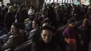 Sejumlah warga Tiongkok menunggu kereta api untuk mudik ke kampung halaman mereka di stasiun kereta api Beijing, Tiongkok (10/2). (AFP Photo/Fred Dufour)
