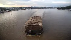 Sebuah kapal tongkang berisi kayu gelondongan ditarik di sepanjang Sungai Mahakam melewati Kota Samarinda, Kalimantan Timur, 4 November 2021. (ADITYA AJI/AFP)