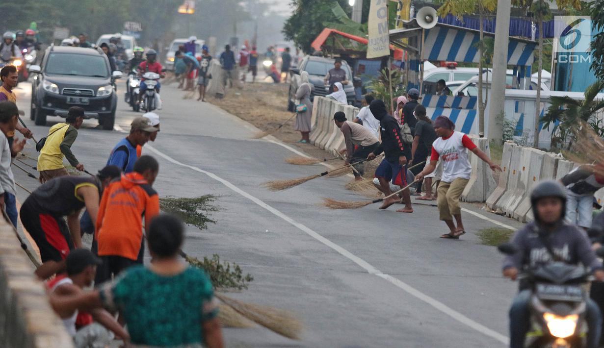 Warga berebut uang yang dilemparkan pengguna jalan menggunakan sapu di Jembatan Sewo, Indramayu, Jawa Barat, Senin (3/6/2019). Kehadiran pencari sedekah tersebut biasanya kian bertambah banyak saat menjelang arus mudik Lebaran. (Liputan6.com/Herman Zakharia)