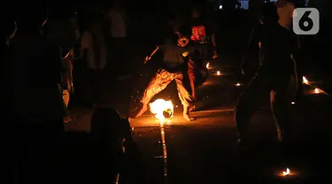 Sejumlah warga saat bermain bola api di Kawasan Rempoa, Tangerang Selatan, Rabu (19/08/2020). Bermain Bola api tersebut dilakukan dalam rangka menyambut peringatan tahun baru Islam 1 Muharram 1442 H. (Liputan6.com/Herman Zakharia)