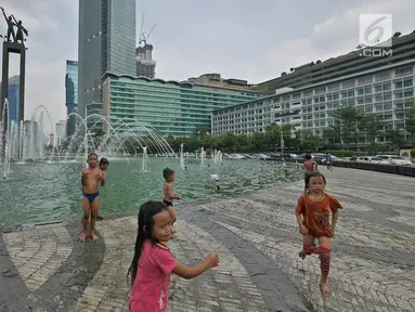 Sejumlah anak bermain air di kolam Bundaran HI, Jakarta, Senin (17/6/2019). Meski ada larangan berenang, sejumlah anak tetap nekat menyebur ke kolam Bundaran HI. (Liputan6.com/Herman Zakharia)