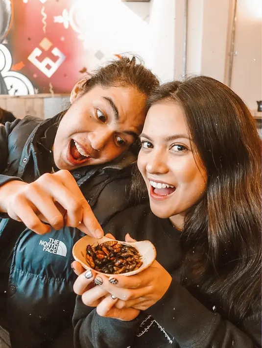 Begitu juga saat momen liburannya yang satu ini. Keduanya terlihat sedang ingin menyantap makanan serangga. Walaupun ngeri, keduanya tetap tampil kece, kan. (Liputan6.com/IG/@aruanmarsha)