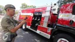 Petugas pemadam kebakaran mengerahkan Mobil Damkar di tempat kejadian kebakaran di kawasan Hj. Nawi, Jakarta, Senin (20/7/2015). Pemadam kebakaran mengerahkan 13 unit mobil Damkar di tempat kejadian kebakaran. (Liputan6.com/Helmi Afandi)
