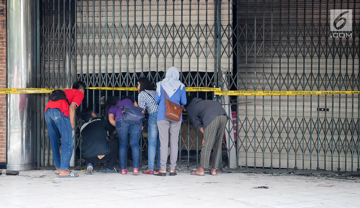 Sejumlah orang melihat kondisi gedung pusat perbelajaan Ramayana, Pasar Minggu, Jakarta, yang terbakar, Kamis (18/5). Api dapat dipadamkan sekitar tiga jam setelah petugas damkar berjibaku dengan si jago merah. (Liputan6.com/Yoppy Renato)