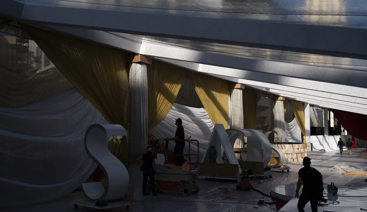Anggota kru bekerja di area kedatangan d Academy Awards ke-94 atau disebut juga piala Oscar pada hari Minggu di luar Teater Dolby, Los Angeles, Rabu (23/3/2022). Piala Oscar 2022 ini disiarkan langsung di ABC pukul 20.00 waktu setempat di lebih dari 200 wilayah di seluruh dunia. (AP Photo/Jae C.Hong