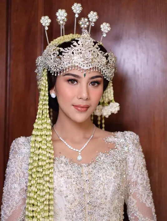 Dalam tampilan yang menawan, Adinda dan Raka mengenakan busana pengantin berwarna putih lengkap dengan sarung batik senada. Dari informasi yang diungkap, pernikahan mereka berlangsung dalam skala terbatas di Opus Ballroom The Tribrata Darmawangsa Jakarta Selatan.  (Liputan6.com/IG/@marlenehariman)