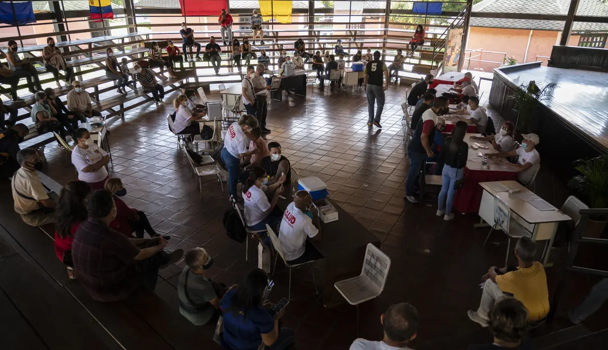 Orang-orang disuntik dengan dosis pertama kandidat vaksin Covid-19 Abdala buatan Kuba selama kampanye vaksinasi massal di kompleks Andres Blanco di Fuerte Tiuna, Caracas, Rabu (30/6/2021). Venezuela pada 24 Juni 2021 menandatangani kontrak untuk membeli 12 juta dosis vaksin Abdala. (Yuri CORTEZ/AFP)