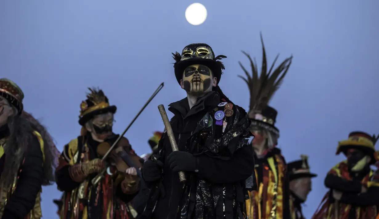 Anggota Powderkeg Morris Dancers berkumpul sambil menari dan memainkan musik di atas Windgather Rocks di High Peak di Derbyshire (1/5). Acara ini dirayakan pada May Day atau awal musim panas. (AFP Photo/Lindsey Parnaby)