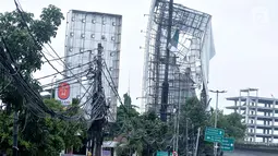 Kondisi papan reklame yang hampir roboh yang berada di kawasan Terminal Kampung Melayu, Jakarta (2/10). Hujan deras disertai angin kencang yang mengguyur Ibu Kota kemarin membuat papan reklame ini hampir roboh.(Liputan6.com/Helmi Afandi)