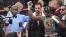 Wasit Robert Byrd mengangkat tangan Badou Jack's usai berhasil mengalahkan George Groves di Las Vegas, Sabtu (12/9/2015). Robert Byrd akan menjadi wasit yang memimpin laga tinju antara Floyd Mayweather dan Conor McGregor. (AFP/Ethan Miller)