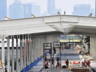 Aktivitas pekerja saat menyelesaikan pembangunan Skybridge Tanah Abang, Jakarta, Minggu (14/10). Jembatan yang menghubungkan Stasiun Tanah Abang dengan Pasar Blok G tersebut rencananya akan diresmikan pada 15 Oktober 2018. (Merdeka.com/Iqbal Nugroho)