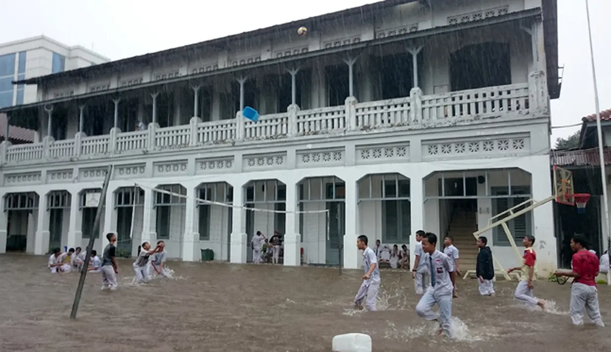  Siswa SMK 1 Budi Utomo beraktivitas di tengah genangan hujan yang merendam sekolah mereka, Jakarta, Senin (9/2/2015). (Antara Foto/Fanny Octavianus)
