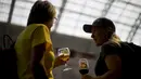 Dua wanita berbincang saat menikmati bir selama The Great British Beer Festival di London (6/8/2019). Great British Beer Festival, yang diselenggarakan CAMRA, menyediakan ratusan bir putih asli, bir internasional dan sari buah asli dan perries. (AFP Photo/Tolga Akmen)