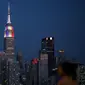 Gedung pencakar langit Empire State di New York memancarkan lampu warna bendera juara Piala Dunia 2018, Prancis, Minggu (15/7). Sebelumnya, pucak gedung terkenal di Amerika Serikat itu selalu menyalakan warna putih. (AFP PHOTO / KENA BETANCUR)