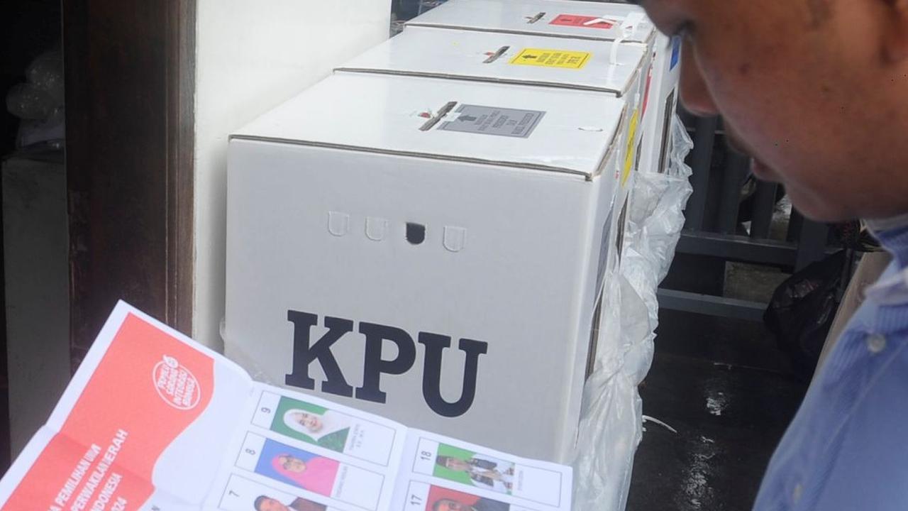 Seorang warga melihat gambar caleg pada salah satu surat suara saat melakukan pencoblosan pada TPS darurat. Foto: merdeka.com / Arie Basuki