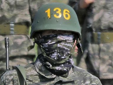 Pemain Tottenham Hotspur, Son Heung-min, berseragam militer lengkap dengan senjata saat mengikuti wajib militer di Korsel, (6/5/2020). Penundaan Premier League karena virus corona dimanfaatkan Son Heung-min untuk mengikuti program wajib militer. (AP/Park Ji-ho)