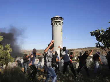 Warga Palestina melempari batu ke arah tentara Israel di Beit Ommar, utara kota Hebron, (25/7/2014). (REUTERS/Mussa Qawasma)