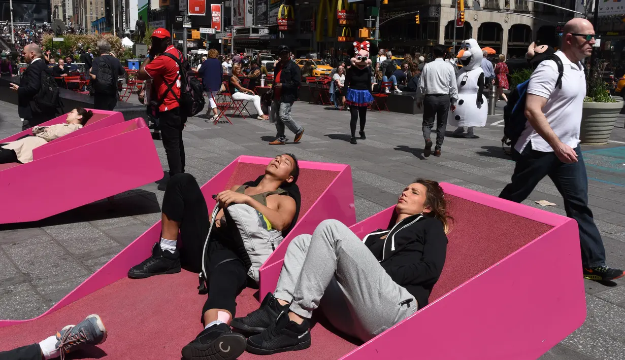 Sejumlah orang menerima tantangan untuk berjemur di sebuah tempat yang telah disediakan di Times Square, New York, AS, Selasa (2/5). (AFP PHOTO / TIMOTHY A. CLARY)
