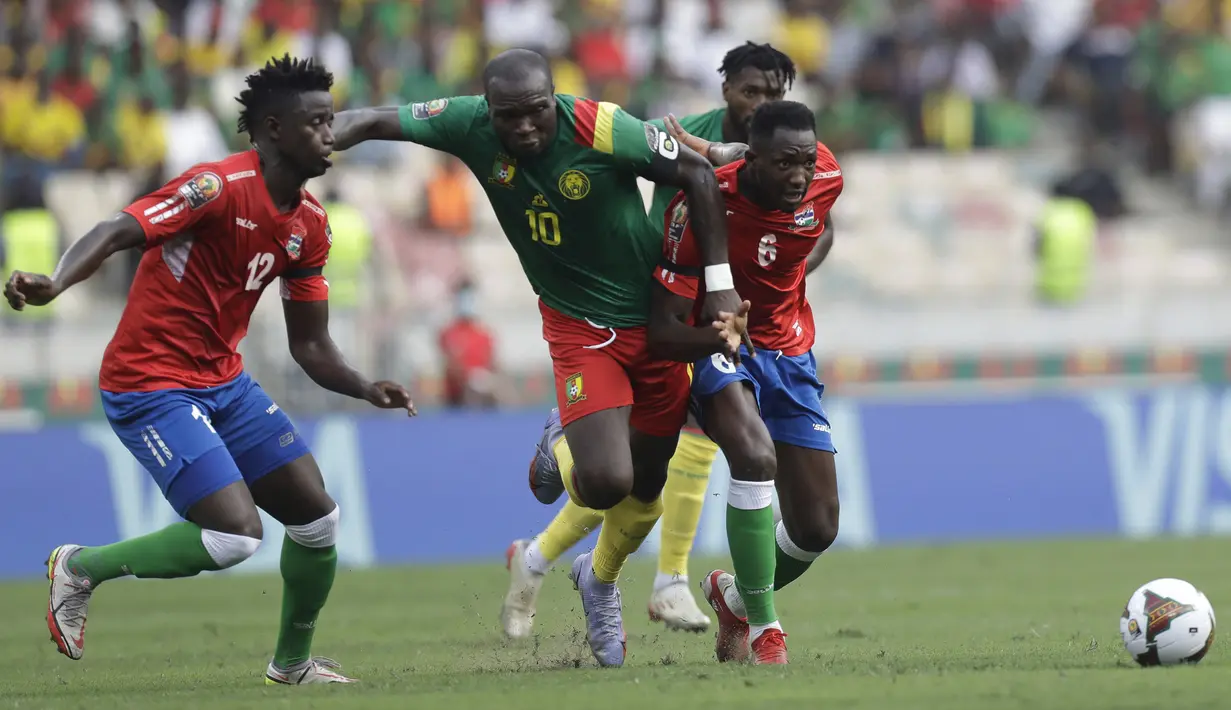 Penyerang Kamerun Aboubakar Vincent (tengah) bersaing dengan pemain Gambia James Gomez dan Sulayman Marreh pada pertandingan perempatfinal Piala Afrika 2021 di Japoma Stadium, Minggu (30/1/2022) dini hari WIB. Kamerun melangkah ke semifinal usai menang atas Gambia, 2-0. (AP Photo/Sunday Alamba)