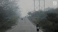 Pengendara motor menembus kabut asap pekat yang menyelimuti Kota Pekanbaru, Riau, Selasa (10/9/2019). Kabut asap akibat kebakaran hutan dan lahan (karhutla) tersebut menurunkan jarak pandang dan kualitas udara turun ke status tidak sehat. (Liputan6.com/Faizal Fanani)