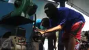 Seorang tersangka memasukan narkoba ke dalam mesin penghancur pada pemusnahan barang bukti tersebut di BNN, Jakarta, Rabu (17/6/2015). Sebanyak 18 kg sabu dan 622 butir ekstasi hasil pengungkapan BNN itu dimusnahkan. (Liputan6.com/Johan Tallo)