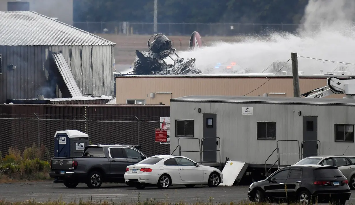 Operasi penyelamatan berlangsung di mana pesawat pengebom era Perang Dunia II milik Amerika Serikat jatuh di Bandara Internasional Bradley, Connecticut, Rabu (2/10/2019). Pesawat Boeing B-17 itu dilaporkan berusaha mendarat ketika kecelakaan itu terjadi. (AP Photo/Jessica Hill)