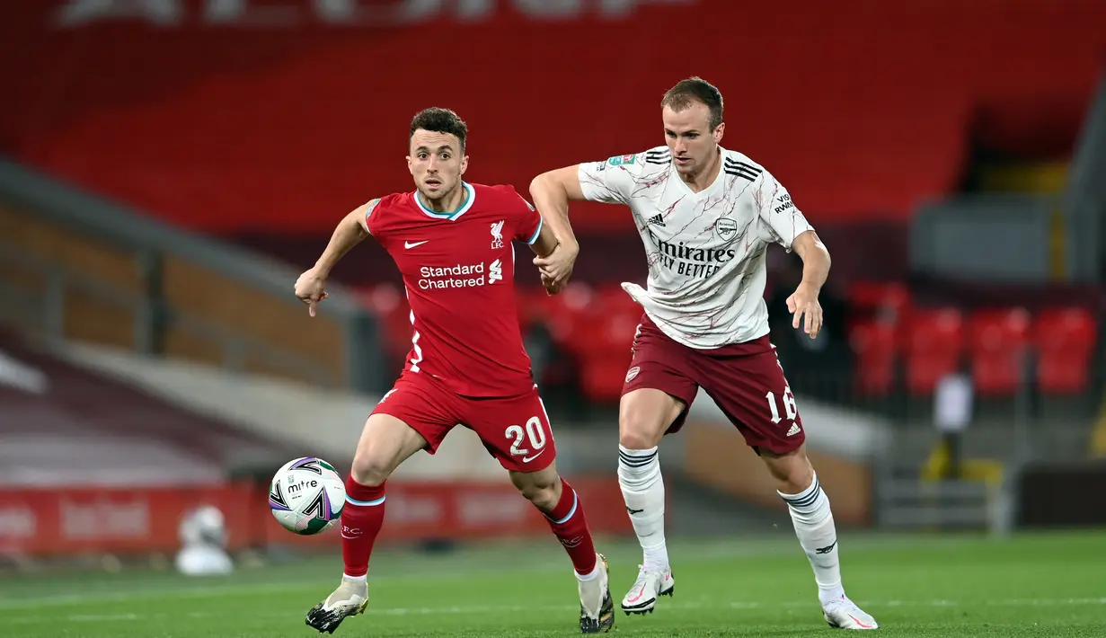 Penyerang Liverpool, Diogo Jota, berebut bola dengan bek Arsenal, Rob Holding, pada laga Piala Liga Inggris di Stadion Anfield, Jumat (2/10/2020) dini hari WIB. Arsenal menang 5-4 atas Liverpool lewat adu penalti. (AFP/Laurence Griffiths)
