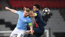 Gelandang Manchester City, Kevin De Bruyne (kiri) berebut bola dengan bek Paris Saint-Germain, Marquinhos dalam laga leg pertama semifinal Liga Champions 2020/2021 di Parc des Princes Stadium, Paris, Rabu (28/4/2021). Manchester City menang 2-1 atas PSG. (AFP/Anne-Christine Poujoulat)