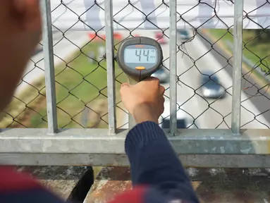 Petugas mengoperasikan alat pengukur kecepatan (speed gun) kendaraan di sekitar Gerbang Tol Palimanan, Cirebon, Jawa Barat, Jumat (7/6/2019). Hal itudilakukan setiap satu jam sekali untuk mengetahui tingkat kepadatan lalu lintas di sepanjang jalur tol Trans Jawa. (Liputan6.com/Immanuel Antonius)