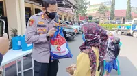 Kapolres Garut AKBP Wirdhanto Hadicaksono membagikan  paket bansos TNI-Polri bagi warga terdampak kebijakan Pemberlakukan Pembatasan Kegiatan Masyarakat (PPKM) Darurat Covid-19 di Garut. (Liputan6.com/Jayadi Supriadin)