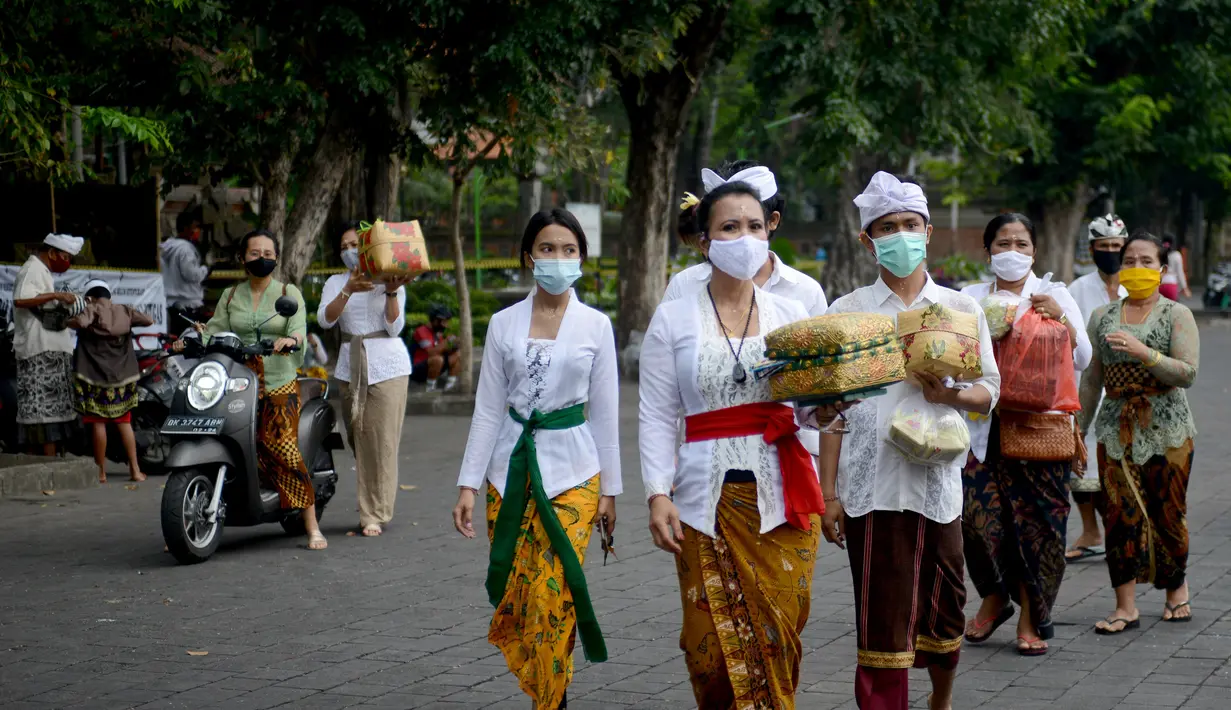 Umat Hindu tiba untuk merayakan Hari Raya Galungan di Pura Jagat Natha di Denpasar, di pulau Bali (16/9/2020). Galungan dirayakan umat Hindu di Bali sebagai hari kemenangan Dharma (Kebaikan) melawan Adharma (Keburukan). (AFP Photo/Sonny Tumbelaka)