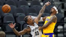Pebasket Los Angeles Lakers, Kentavious Caldwell-Pope, berebut bola dengan pebasket San Antonio Spurs, DeMar DeRozan, pada laga NBA di AT&T Center, Kamis (31/12/2020). LA Lakers menang dengan skor 121-107. (AP/Eric Gay)