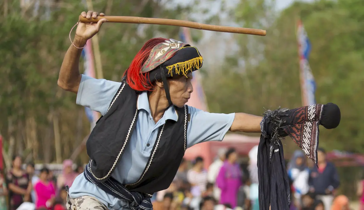 Seorang pria berpakaian seperti prajurit tradisional melakukan ritual 'Ujungan' atau tari sabet di Desa Karang Jati, Banjarnegara, Jateng, Jumat (23/10). Pertarungan rotan antara dua orang ini merupakan ritual untuk meminta hujan. (REUTERS/Nicholas Owen)