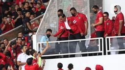 Presiden Joko Widodo (kedua kiri depan) saat memberi botol berisi minuman kepada salah satu supporter yang menyaksikan laga timnas Indonesia melawan Thailand pada lanjutan kualifikasi Grup A Piala AFF 2022 di Stadion Utama Gelora Bung Karno, Jakarta, Kamis (29/12/2022). Laga berakhir imbang 1-1 meski Indonesia sempat unggul lewat gol yang dicetak Marc Anthony Klok lewat titik putih. (Liputan6.com/Helmi Fithriansyah)