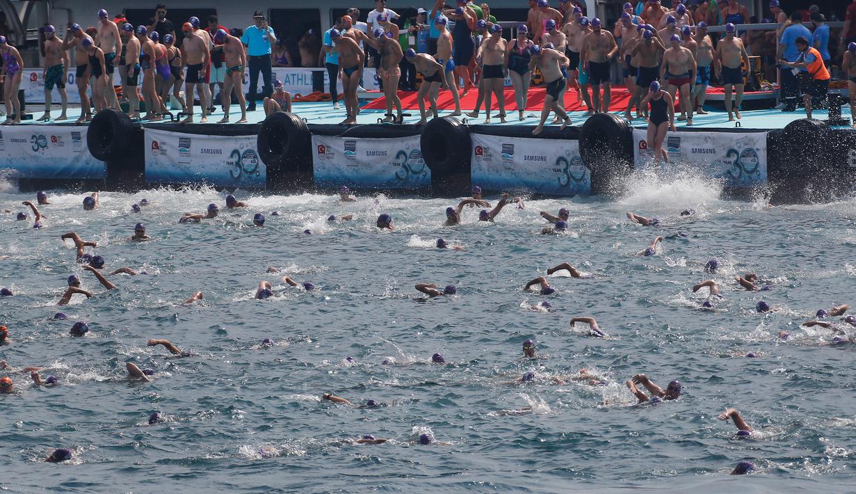 Ratusan atlet renang mengikuti lomba renang dari Asia hingga Eropa di Selat Bosphorus ke-30, Istanbul, Turki, (22/7). Lebih dari 2.000 peserta terjun dari feri dan berenang sejauh sekitar 6,5 km di acara tersebut. (AP Photo/Lefteris Pitarakis)