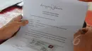 Seorang pedagang melihat surat kontrak kerja sama saat pembuatan tanda pengenal di Kawasan Lenggang Jakarta, Monumen Nasional, Jakarta, Rabu (8/4/2015). (Liputan6.com/Herman Zakharia) 