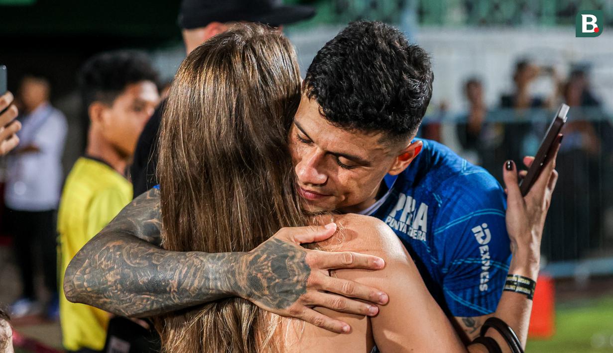 Striker Persib Bandung, Ciro Alves memeluk sang istri, Maria Eduarda dalam perayaan gelar juara Championship Series BRI Liga 1 2023/2024 setelah mengalahkan Madura United 3-1 pada laga final leg kedua di Stadion Gelora Bangkalan, Madura, Jumat (31/5/2024). (Bola.com/Bagaskara Lazuardi)