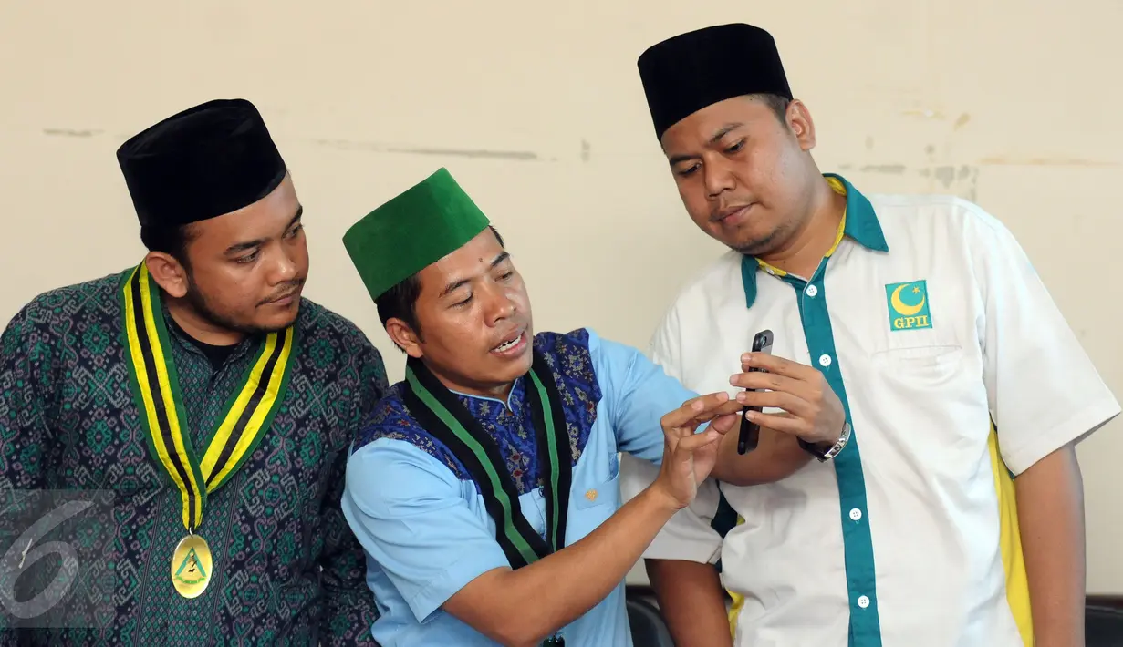 Ketua Umum PB HMI, Mulyadi P Tamsir (tengah) mengecek foto bentrok massa dengan polisi saat aksi damai 4 November, Jakarta, Sabtu (5/11). HMI, PII, dan GPII memberikan pernyataan sikap terkait insiden tersebut. (Liputan6.com/Helmi Fithriansyah)