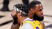 Pebasket Los Angeles Lakers, LeBron James dan Anthony Davis, melakukan selebrasi saat melawan Miami Heat pada gim pertama final NBA di Lake Buena Vista, Kamis (1/10/2020). Lakers menang dengan skor 116-98. (AP Photo/Mark J. Terrill)