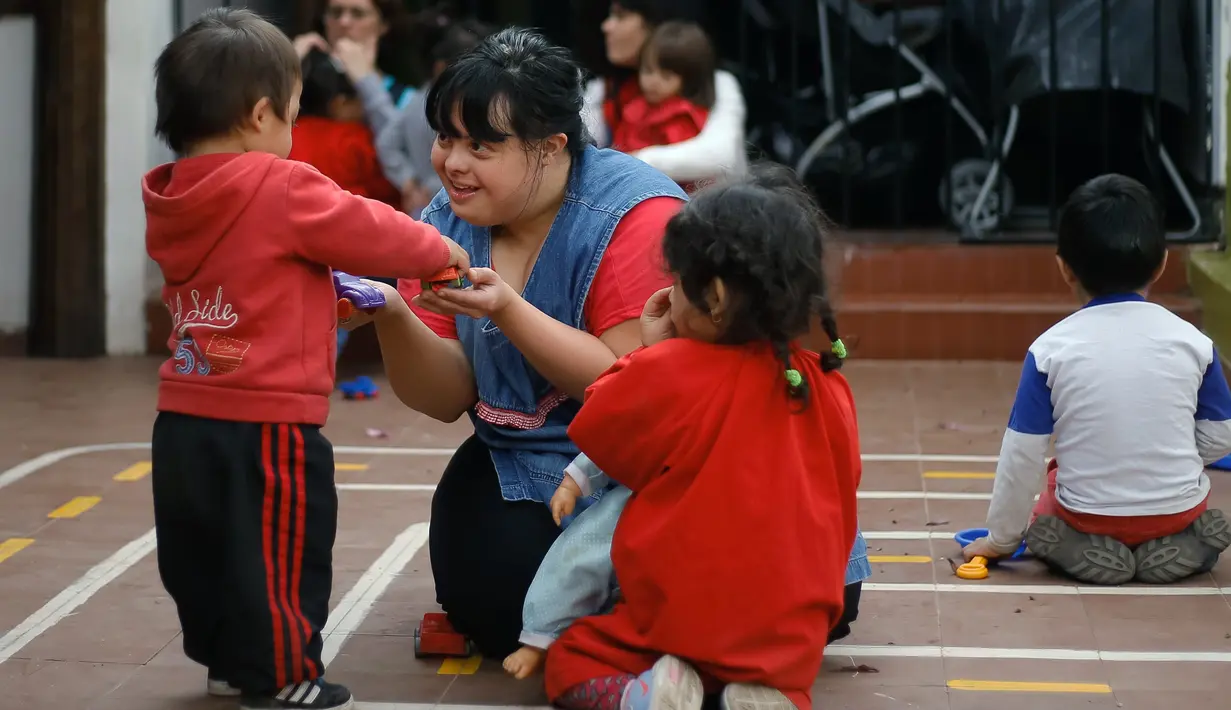 Noelia Garella bermain dengan muridnya di TK Jeromito, Argentina (24/10). Keinginan Noelia menjadi guru TK berawal dari masa kecil yang pahit saat dirinya ditolak masuk ke sebuah sekolah, bahkan dirinya disebut 'Monster'. (AFP Photo/Diego Lima)