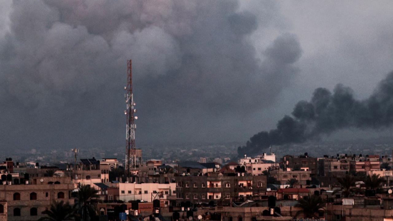 Foto yang diambil dari Rafah ini memperlihatkan kepulan asap yang membumbung tinggi di angkasa Kota Khan Yunis di Jalur Gaza selatan selama agresi Israel yang  melakukan pemboman pada 16 Januari 2024.<br>