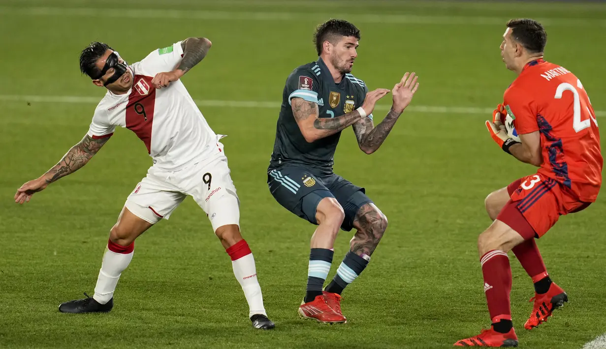 Kiper Argentina Emiliano Martinez mencegat tembakan pemain Peru Gianluca Lapadula (kiri) pada pertandingan kualifikasi Piala Dunia 2022 di Buenos Aires, Argentina, Kamis (14/10/2021). Argentina menang 1-0. (AP Photo/Natacha Pisarenko)