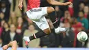 Pemain Manchester United, Anthony Martial (atas) melompat melewati adangan pemain Burton  Albion, Tom Flanagan pada laga Piala Liga Inggris di Old Trafford, Manchester (20/9/2017). MU menang 4-1. (AFP/Paul Ellis)