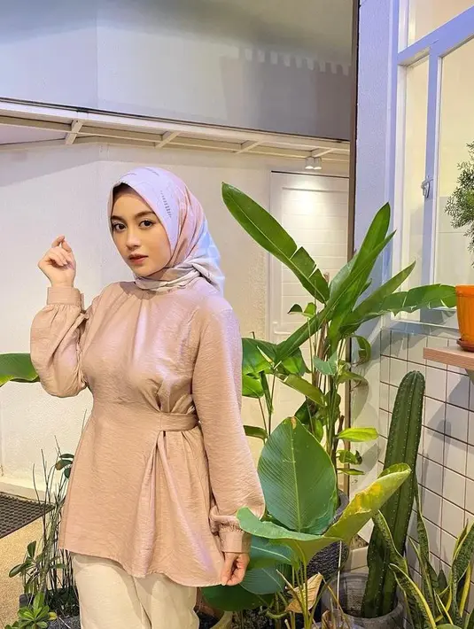 Perpaduan blouse warna pink pastel, kulot putih, dan hijab segi empat warna pink bermotif bisa memberikan kesan lembut pada look-mu. (Instagram/nblh.ayu).