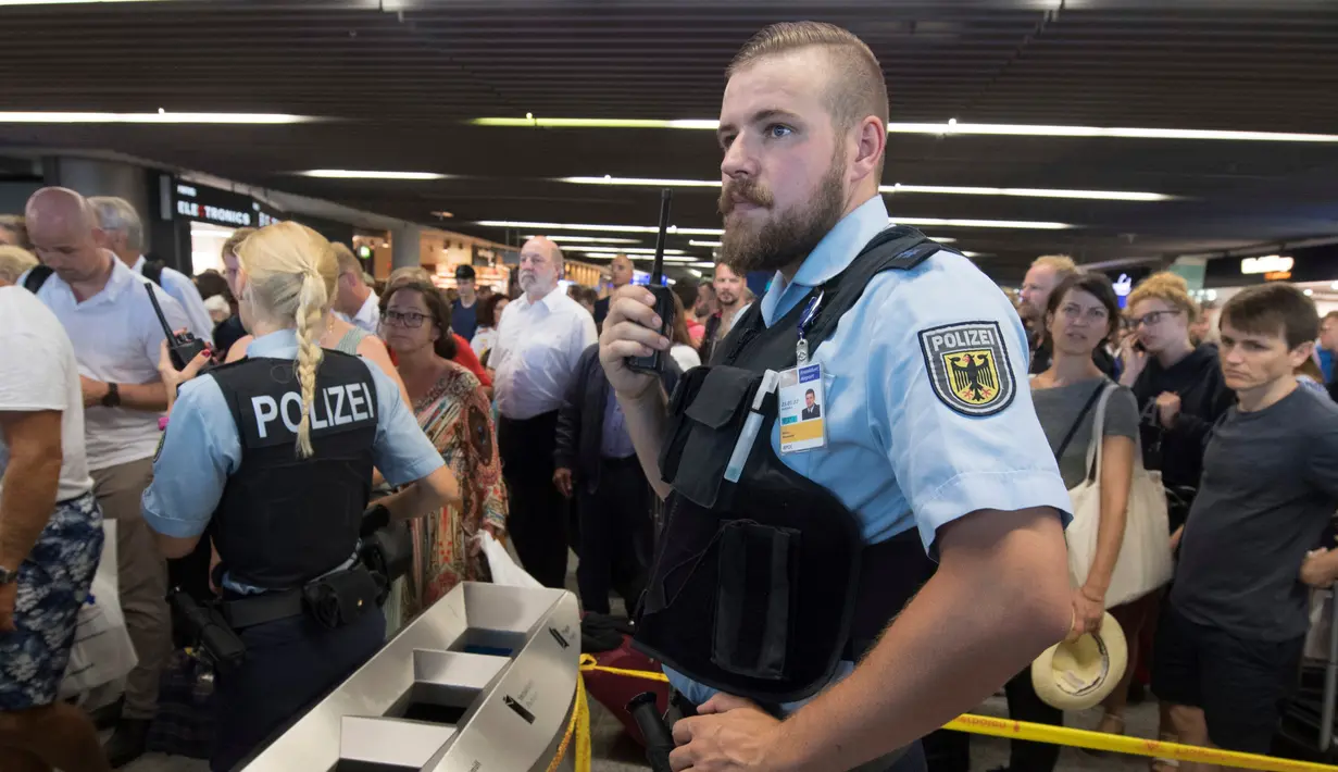 Petugas kepolisian menutup boarding gate untuk masuk pesawat di terminal 1 Bandara Frankfurt, Jerman, Selasa (7/8). Sejumlah penerbangan harus dibatalkan setelah seorang yang tidak dikenal menyusup melewati pos pemeriksaan. (Boris Roessler/dpa via AP)