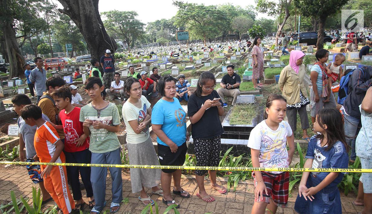 Warga berkumpul saat petugas forensik membongkar makam Abi Qowi Suparto (20) yang diduga mencuri vape senilai 1,6 juta di TPU Karet, Jakarta Pusat, Selasa (12/9). Pembongkaran guna mengetahui penyebab kematian Abi. (Liputan6.com/Immanuel Antonius)