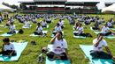 Ratusan warga melakukan gerakan yoga saat mengikuti sesi yoga massal di Stadion Afraha di Nakuru, Kenya (15/6/2019). Acara yoga massal ini untuk memperingati Hari Yoga Internasional. (AFP Photo/Suleiman Mbatiah)