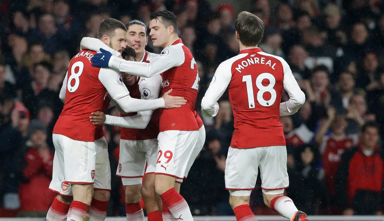 Pemain Arsenal merayakan golnya saat melawan Everton dalam pertandingan Liga Inggris di Stadion Emirates, London (3/2). Dalam pertandingan ini Aaron Ramsey berhasil hattrick dan Aubameyang mencetak gol debut. (AP Photo / Alastair Grant)